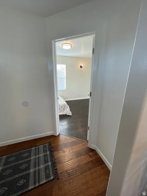 Corridor featuring dark wood finished floors and baseboards