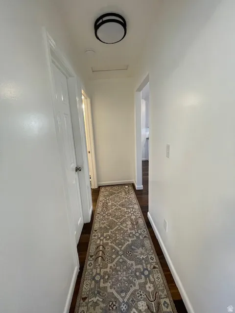 Hallway featuring baseboards and dark wood-style floors