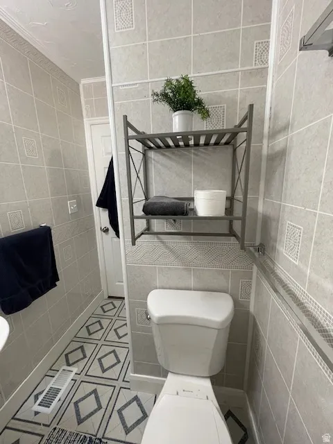 Half bathroom with tile walls and light tile patterned flooring