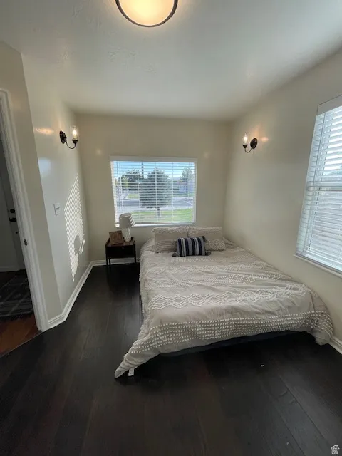 Bedroom featuring dark wood-type flooring and baseboards