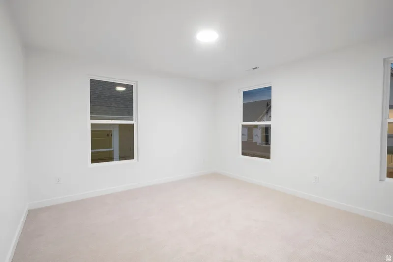 Unfurnished room featuring light carpet