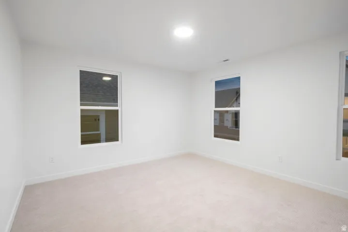 Unfurnished room featuring light carpet