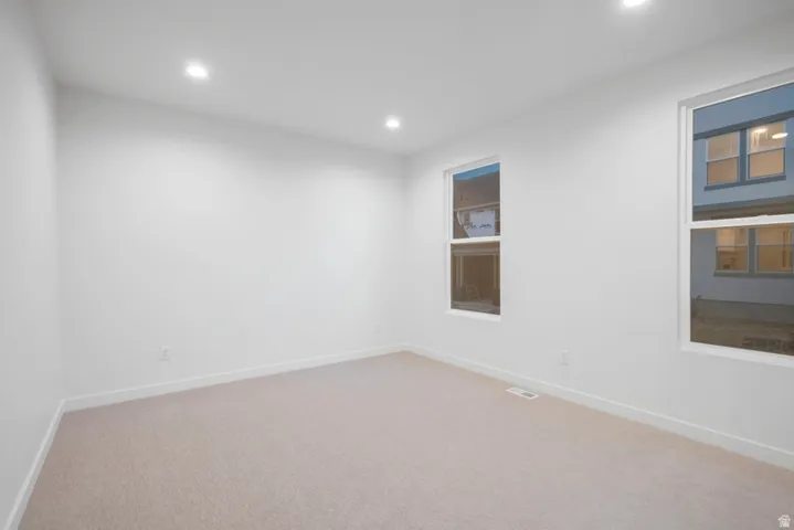 Spare room featuring recessed lighting and light colored carpet