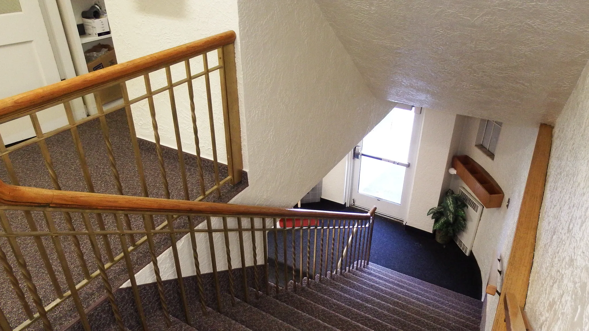 Staircase with carpet floors, a textured wall, and a textured ceiling