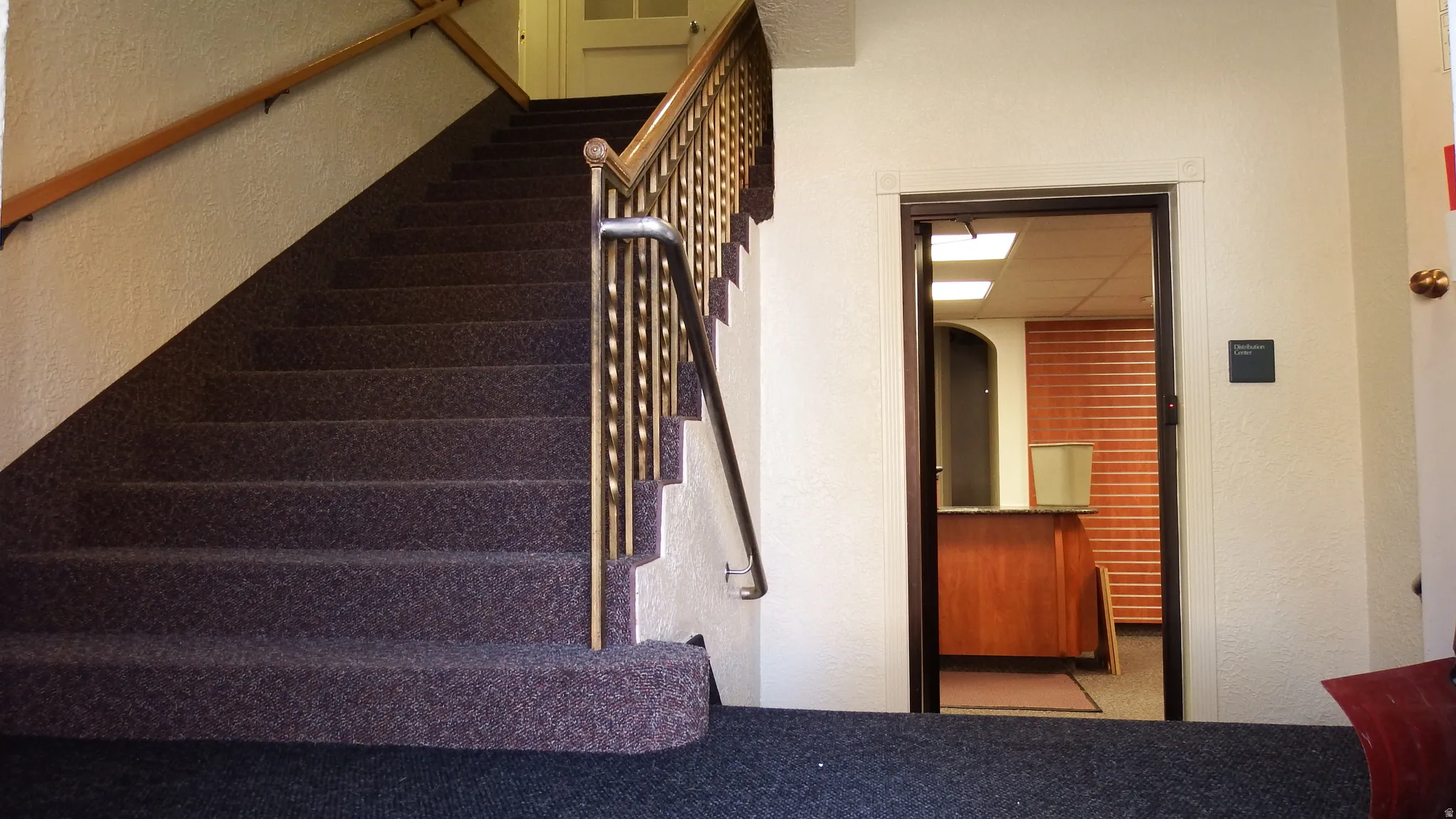 Staircase featuring a textured wall