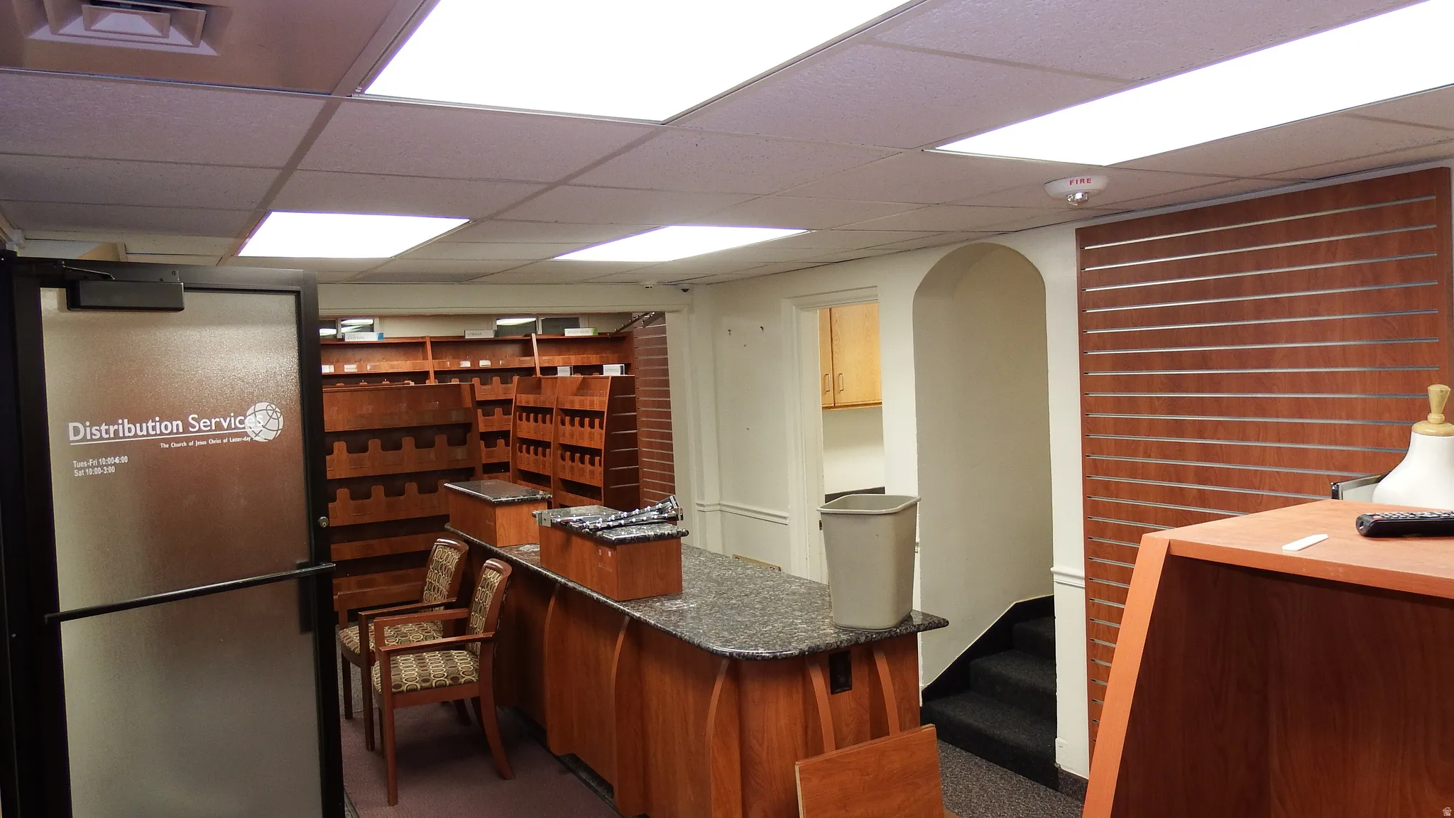 Kitchen featuring a drop ceiling, dark stone counters, and arched walkways