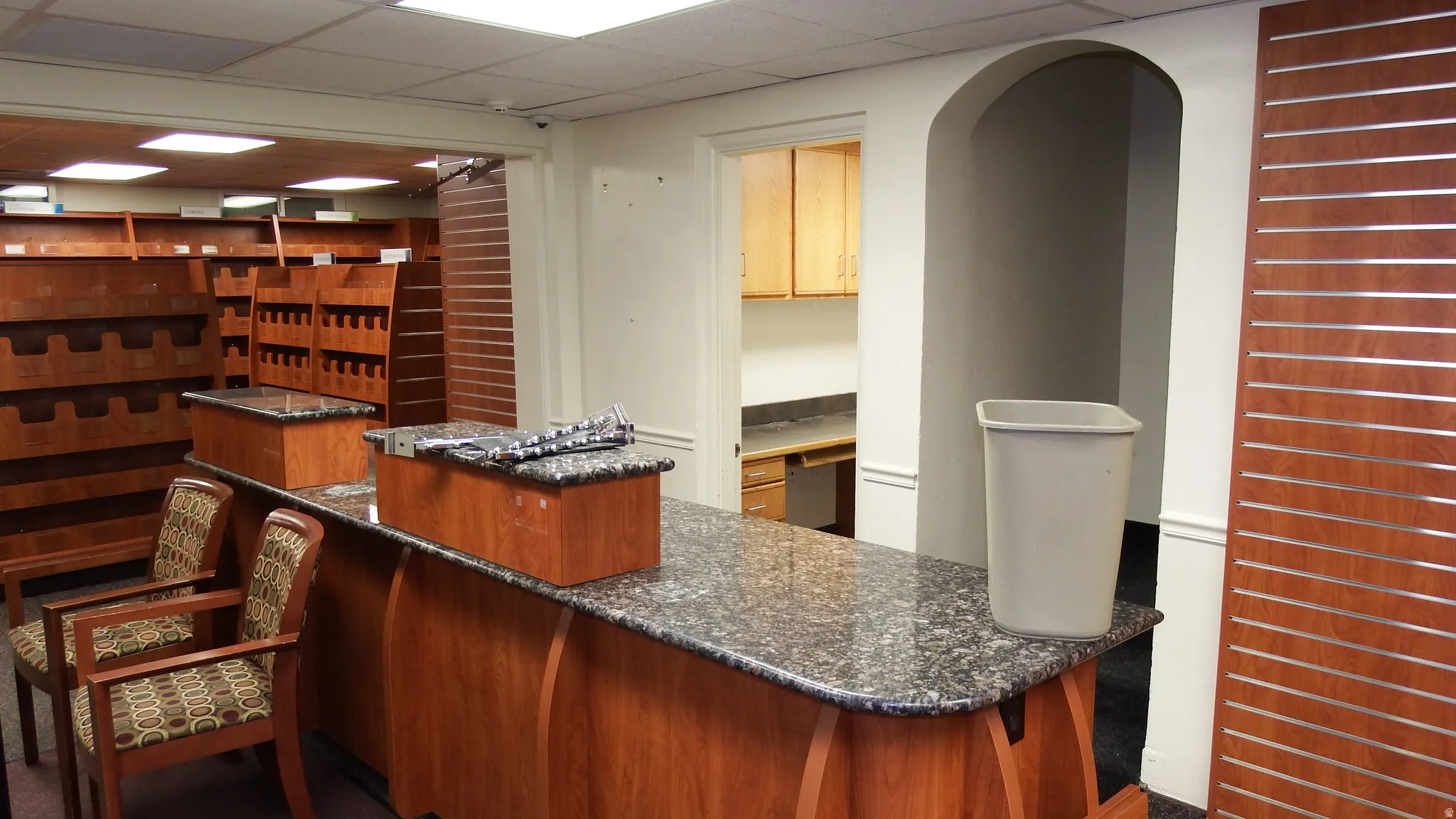 Bar with a drop ceiling and dark stone counters