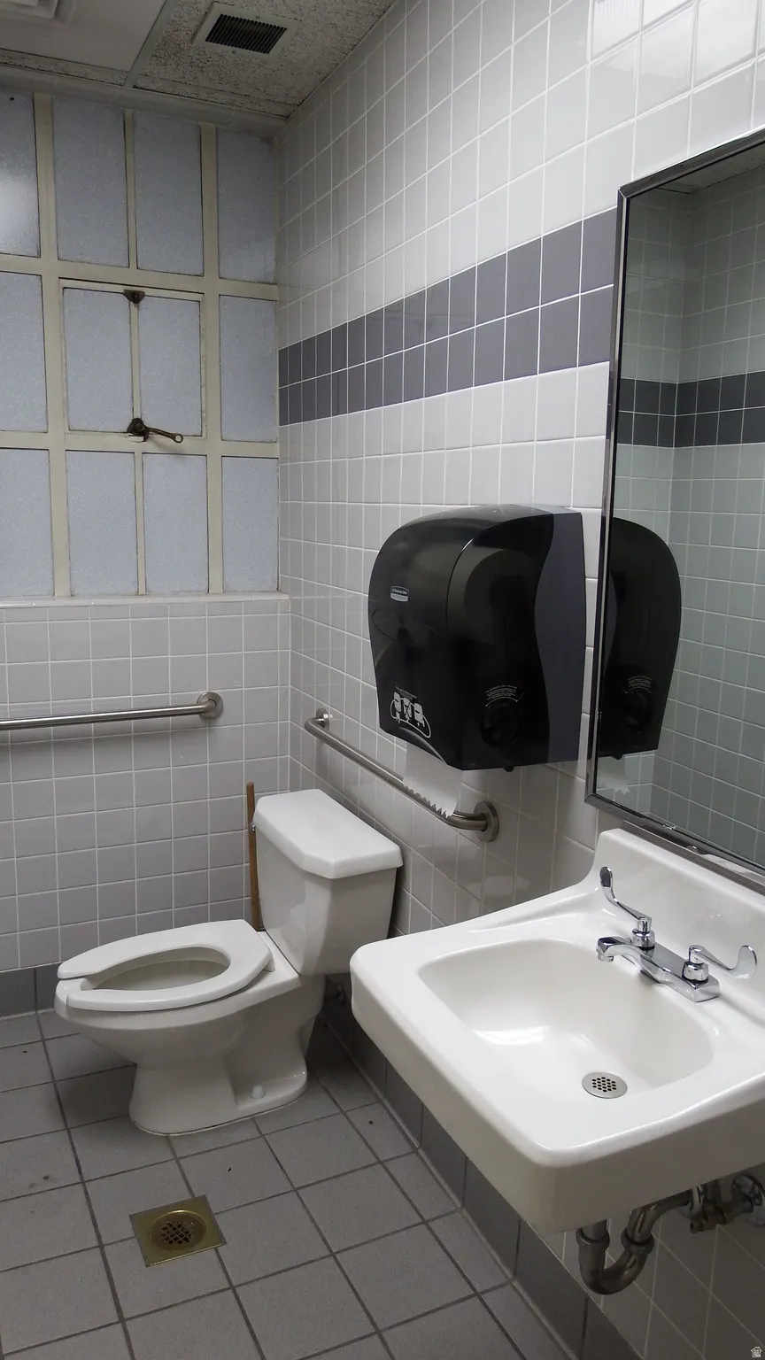 Bathroom featuring tile walls and light tile patterned flooring