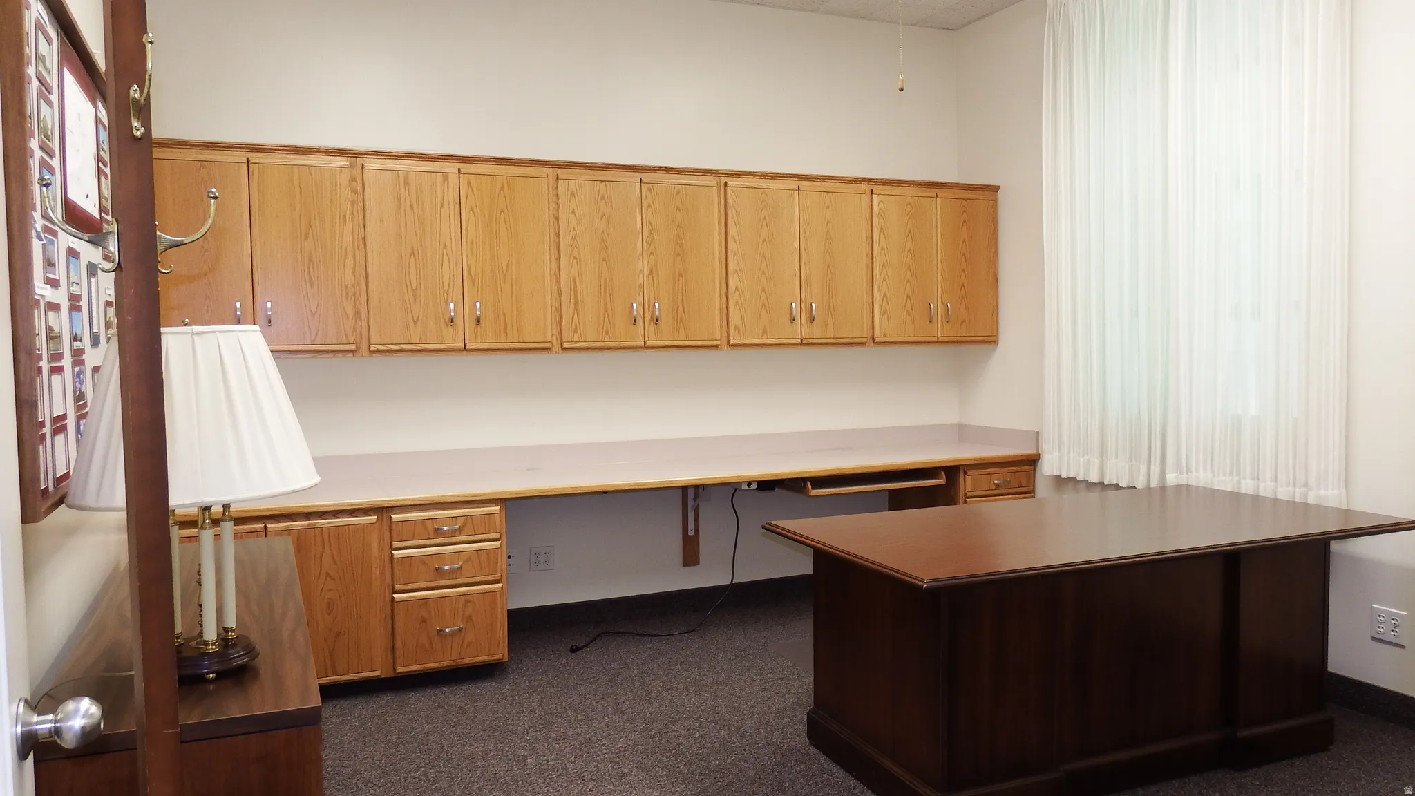 Unfurnished office featuring built in study area and dark colored carpet