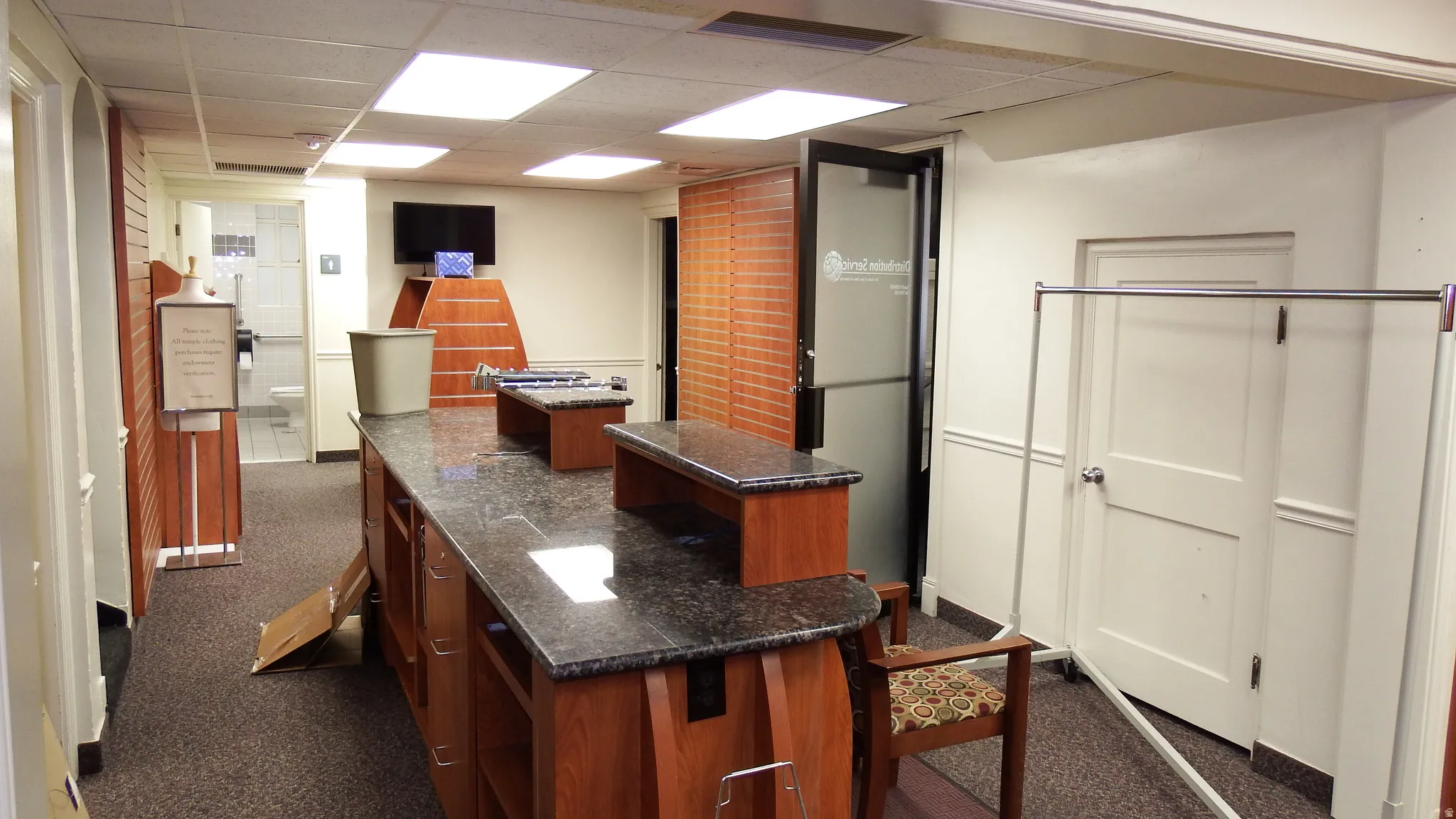 Kitchen featuring a drop ceiling, a kitchen island, dark stone counters, and dark carpet