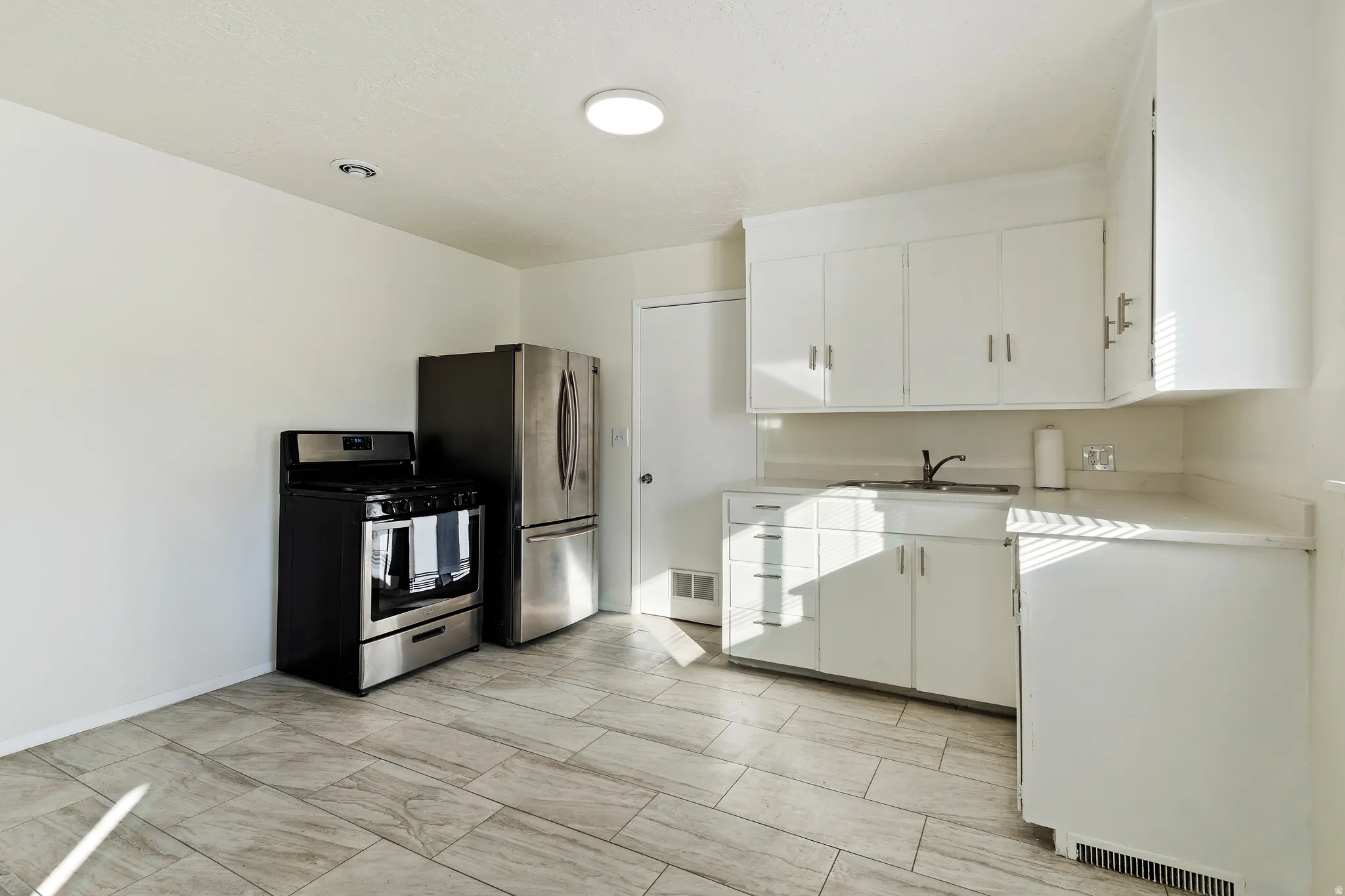 Unit .1Kitchen featuring stainless steel appliances and white cabinetry