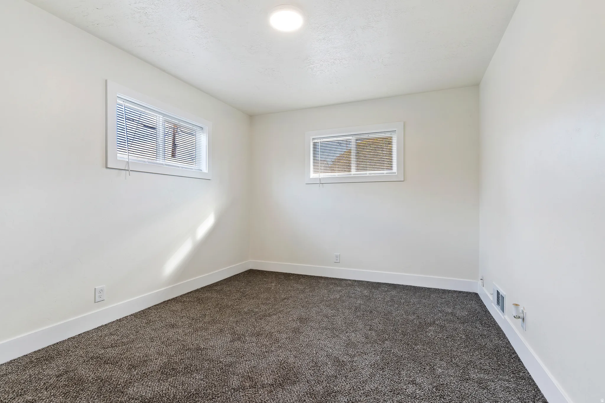 Bedroom with dark colored carpet and baseboards