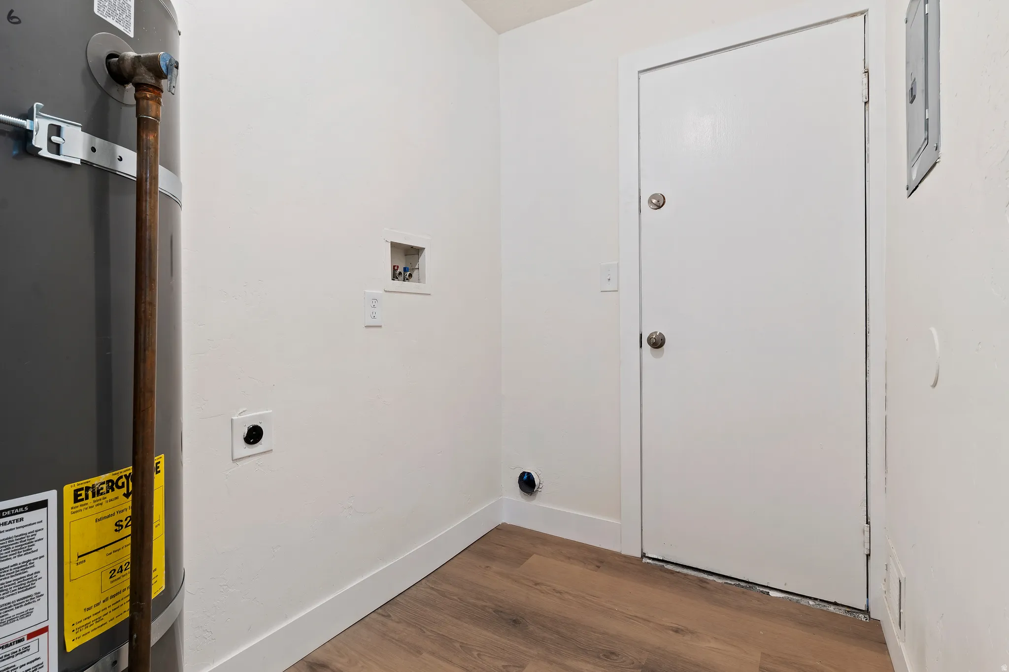 Unit 2 washroom with strapped water heater, wood finished floors, electric dryer hookup, and washer hookup