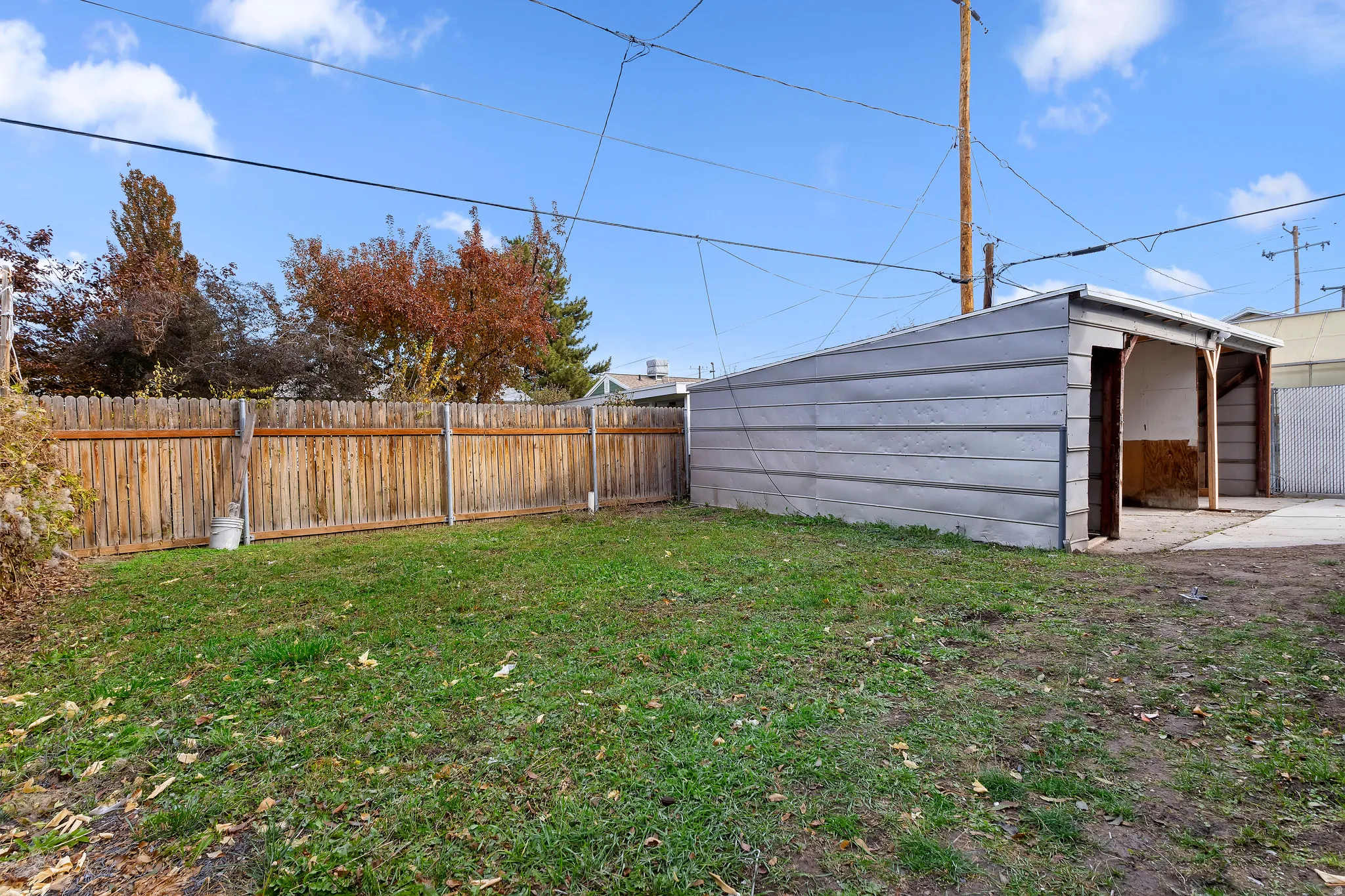 Fenced backyard with view of carport