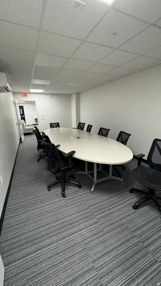Home office with a drop ceiling and an AC wall unit
