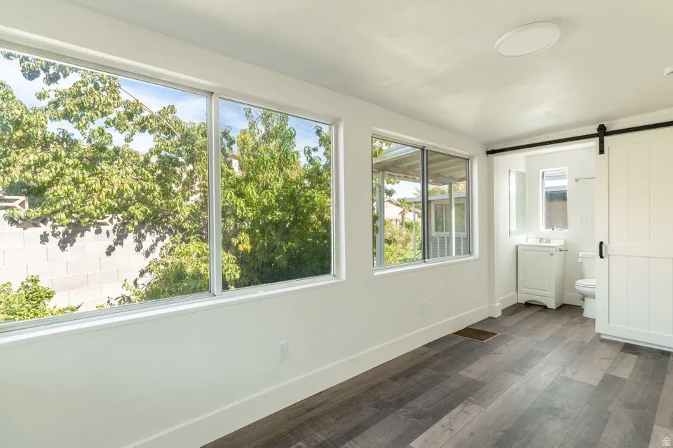 Unfurnished sunroom with a barn door