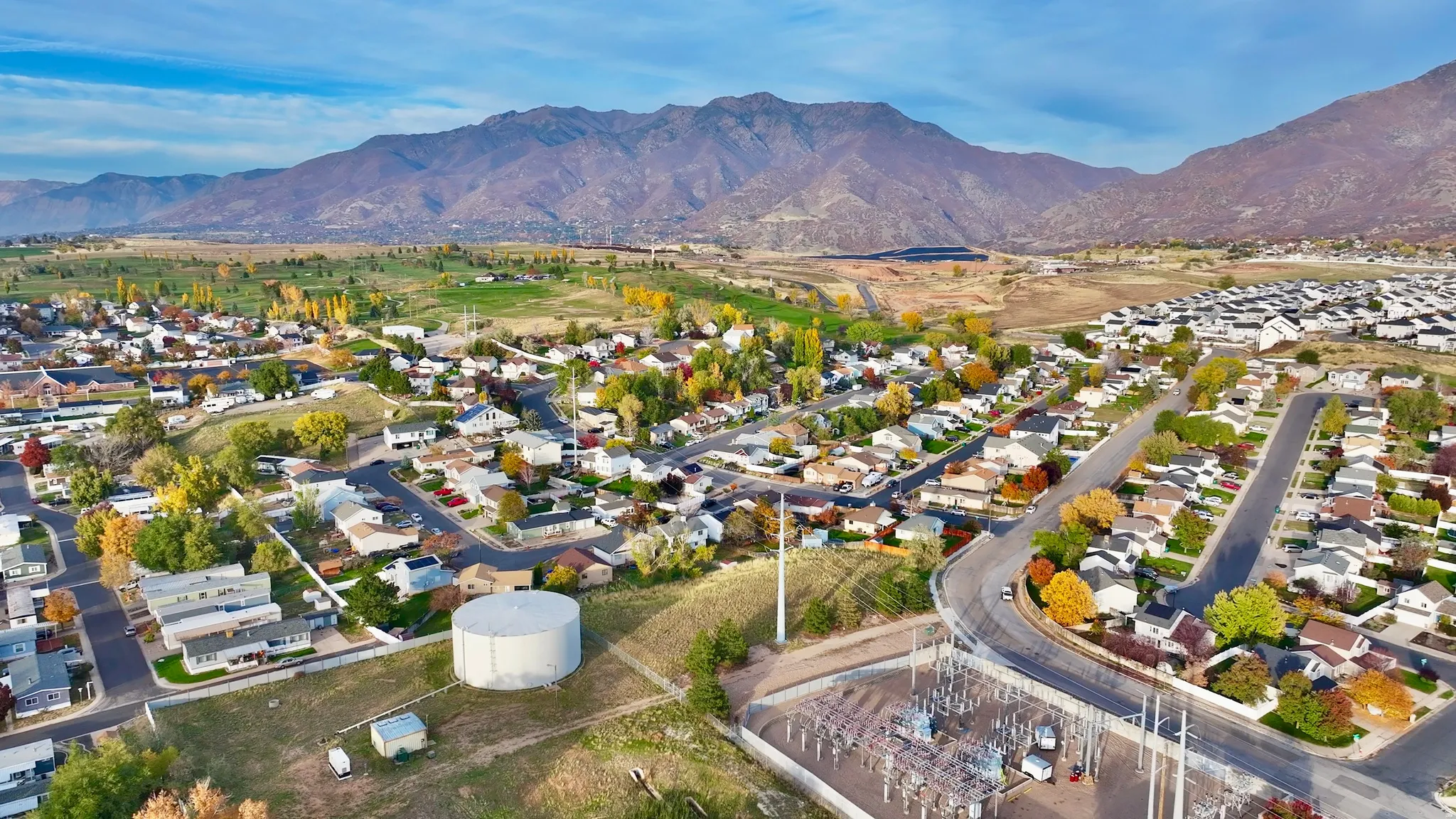 Aerial view of property's location with nearby suburban area and a mountainous background