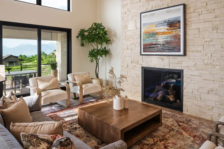 Example of living room with a stone fireplace, wood finished floors, and a mountain view