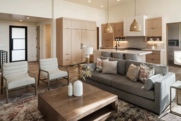 Example of living room featuring a towering ceiling, wood finished floors, and recessed lighting