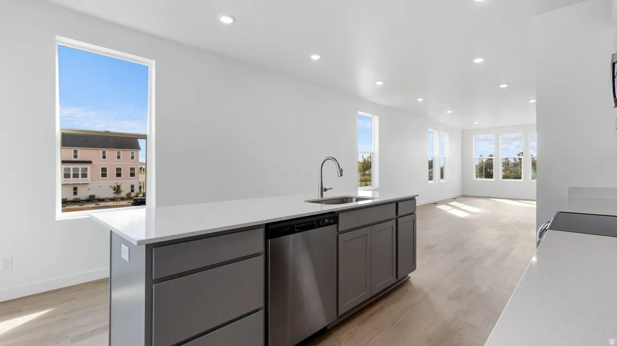 Kitchen with gray cabinets, recessed lighting, a kitchen island with sink, light wood-style flooring, and stainless steel dishwasher