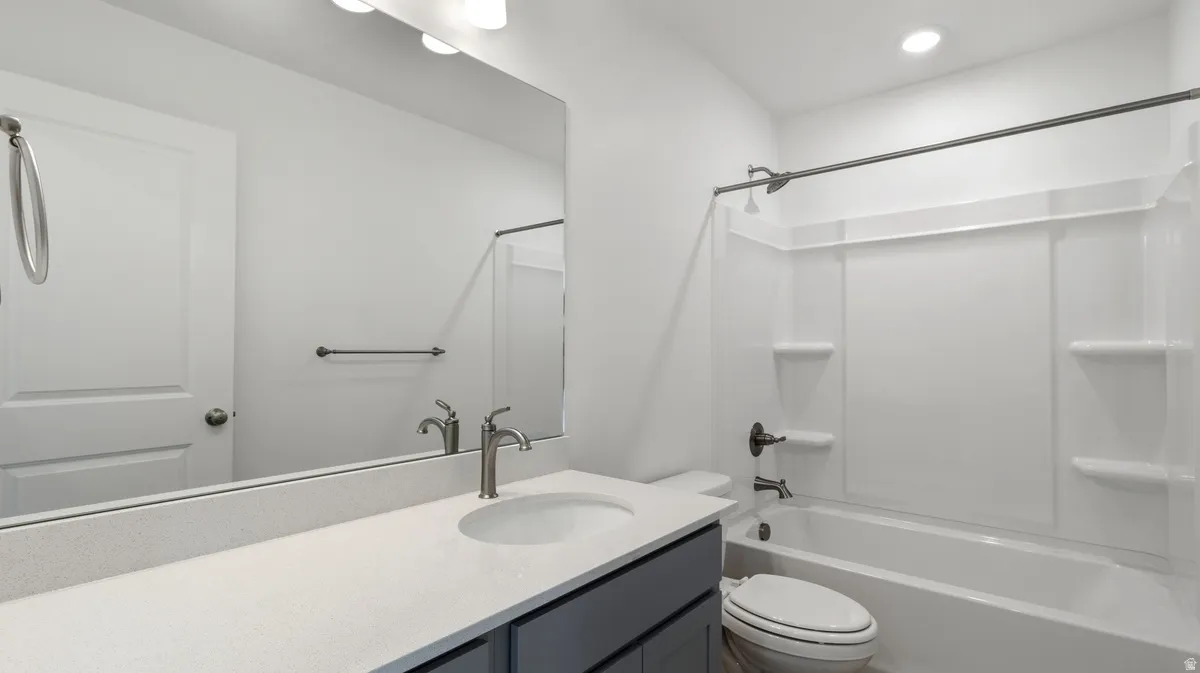 Bathroom featuring shower / bathtub combination, vanity, and recessed lighting