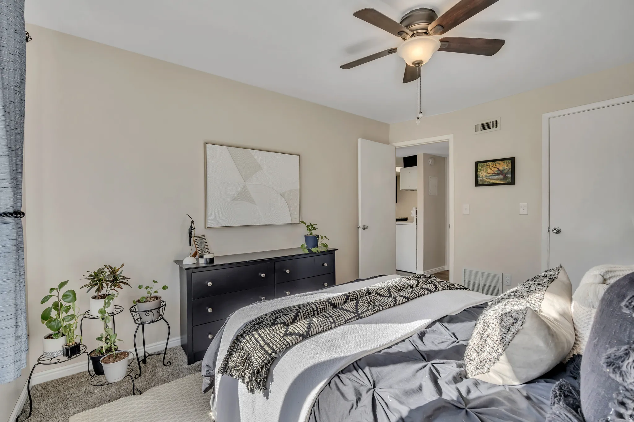 Primary bedroom with walk-in closet, carpet & fan