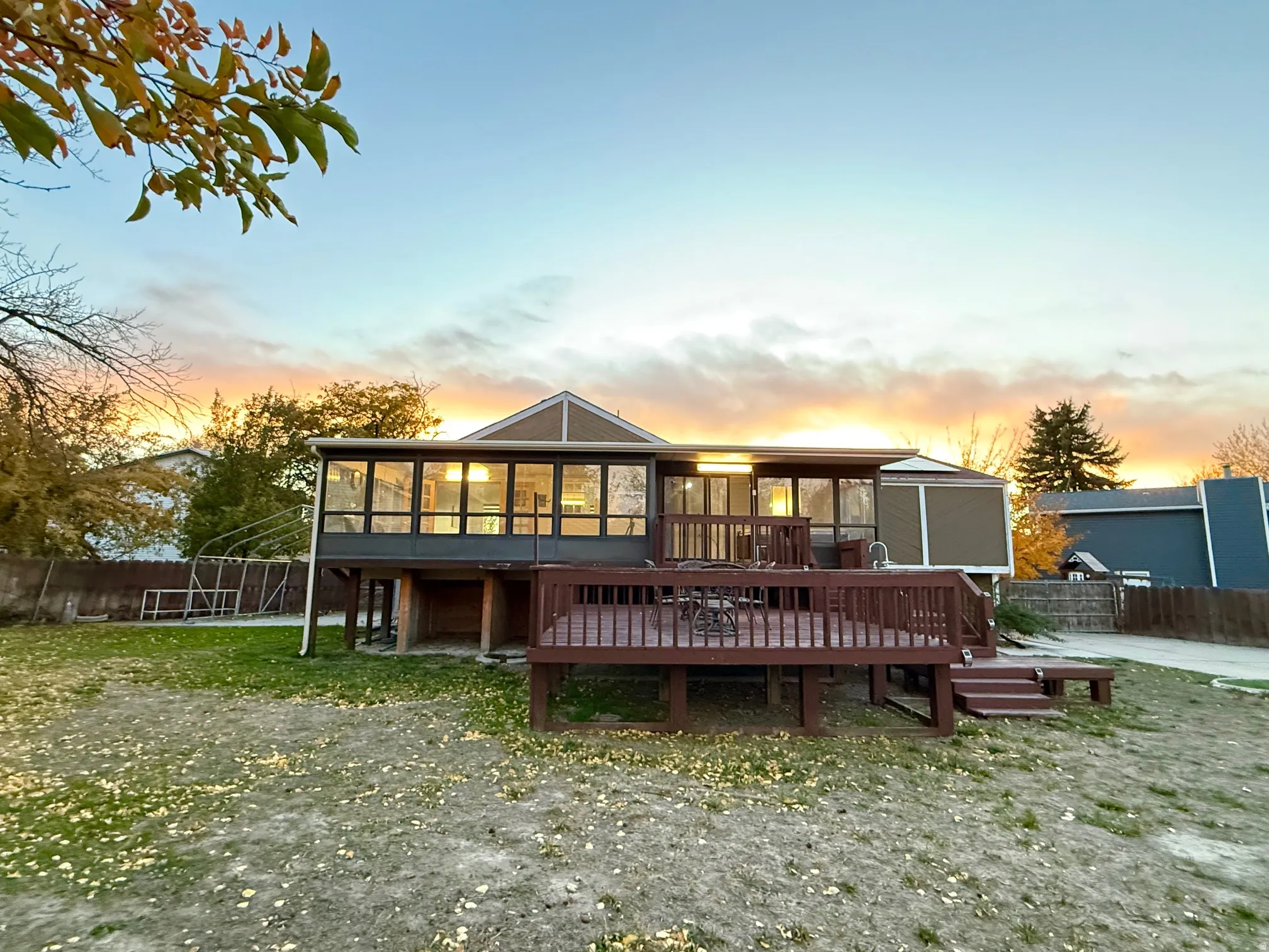 Back of property with a sunroom and a deck