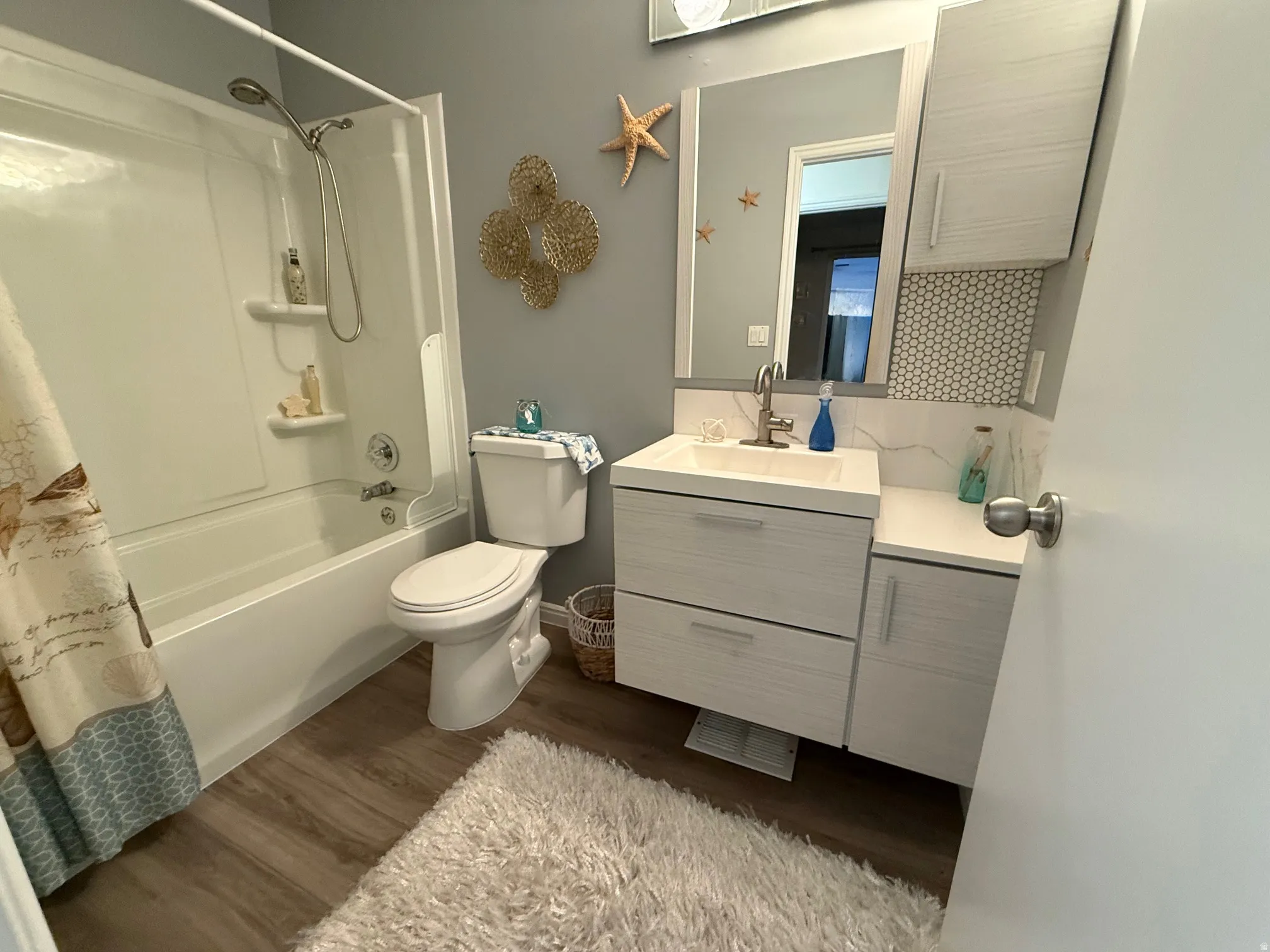 Full bathroom with vanity, dark wood finished floors, shower / bath combo, and backsplash