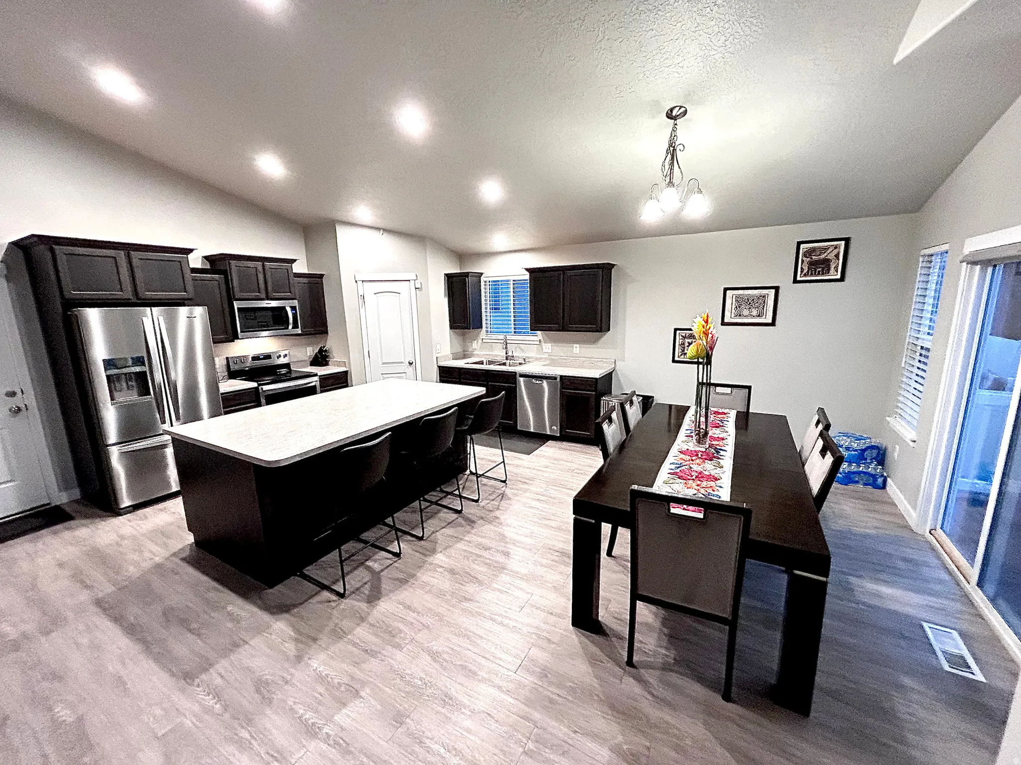 Kitchen featuring lofted ceiling, appliances with stainless steel finishes, a center island, light wood finished floors, and a breakfast bar
