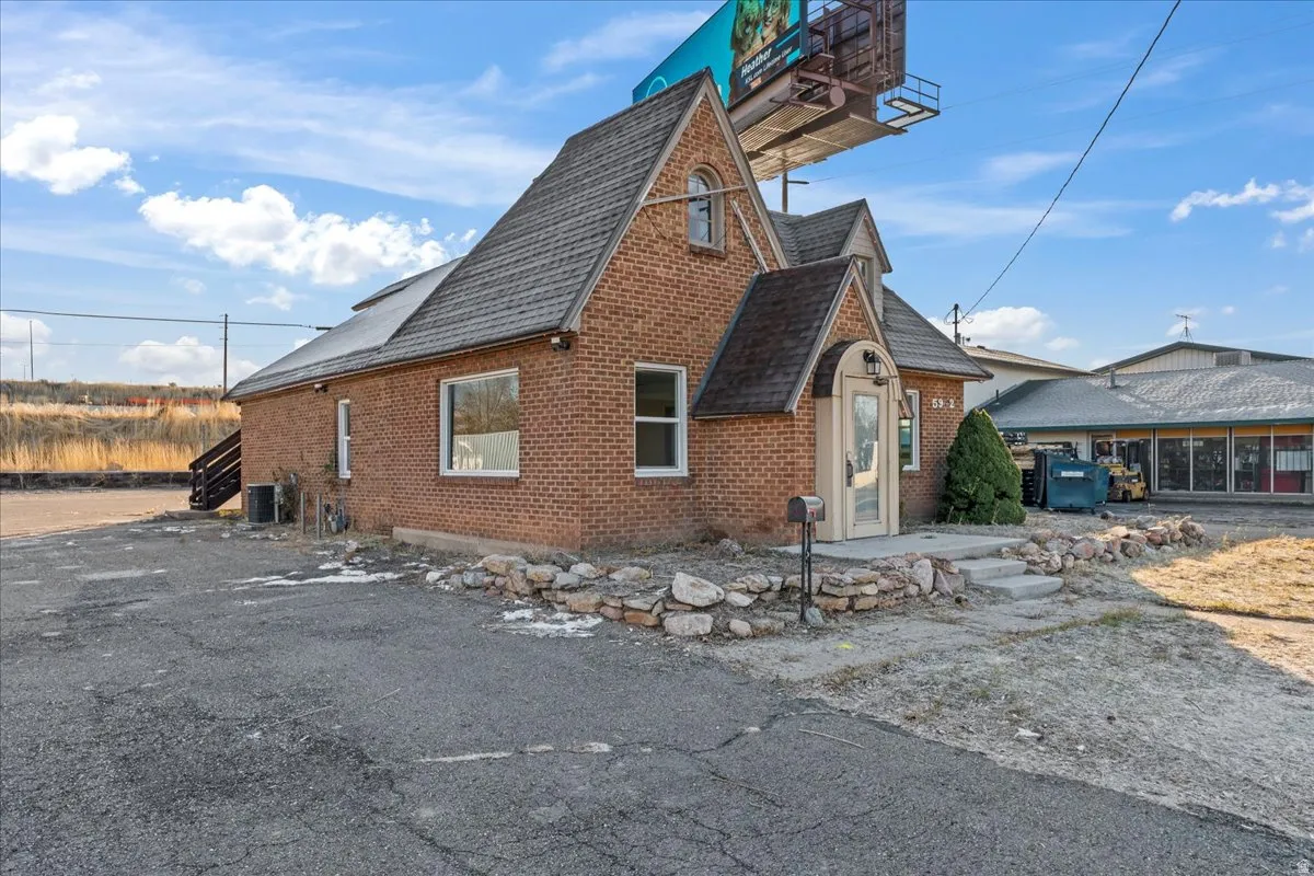 View of home's exterior featuring brick siding and a shingled roof