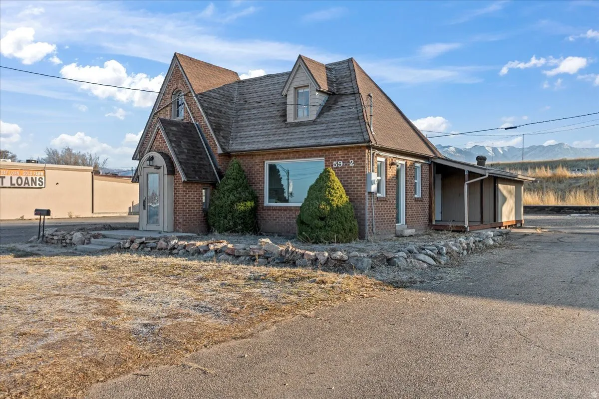 View of property exterior featuring brick siding and a shingled roof