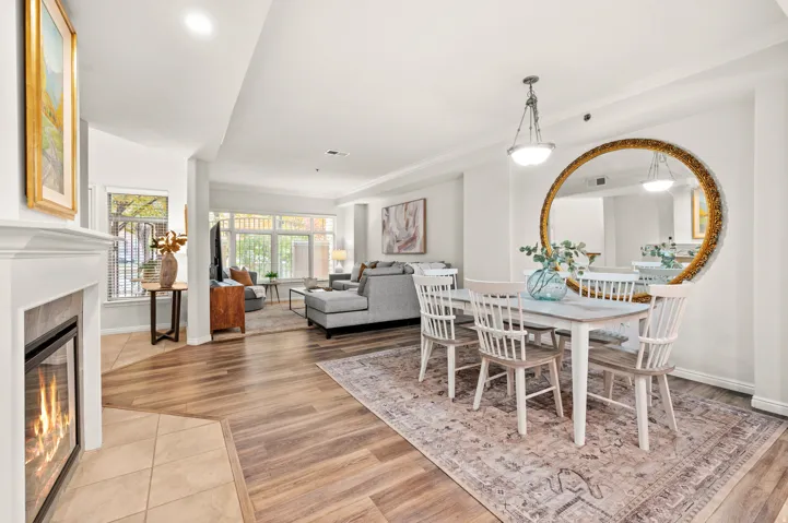 Dining area with a cozy fireplace, LVP flooring, and LED recessed lighting