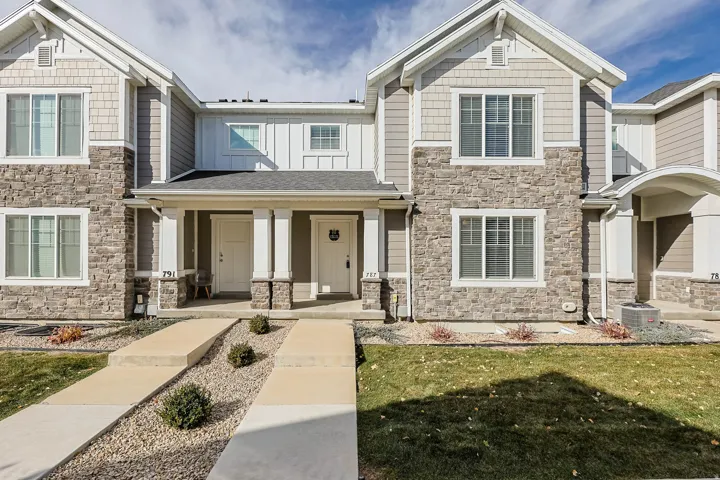 Craftsman inspired home with stone siding, a porch, a front yard, and board and batten siding