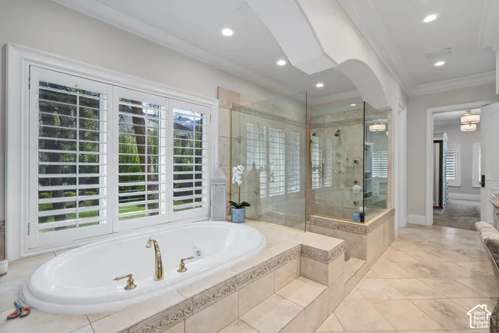 Full bathroom with a bath, ornamental molding, a shower stall, healthy amount of natural light, and light tile patterned flooring