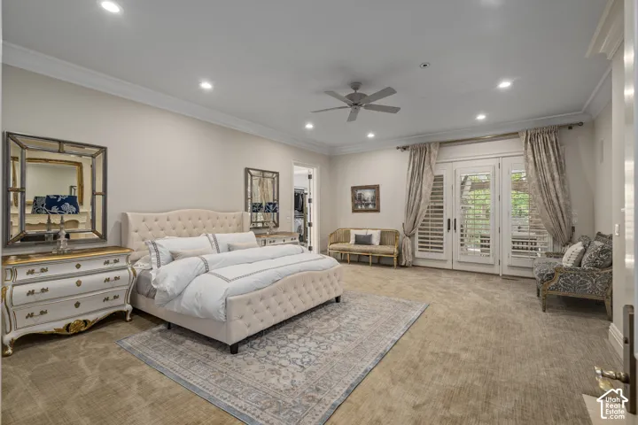 Carpeted bedroom with a spacious closet, crown molding, access to exterior, recessed lighting, and ceiling fan