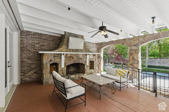 View of patio / terrace featuring an outdoor living space with a fireplace and a ceiling fan