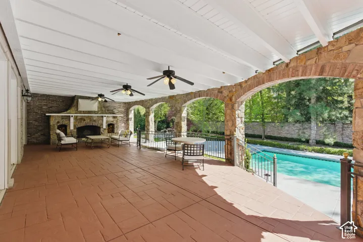 View of patio featuring an outdoor pool and ceiling fan
