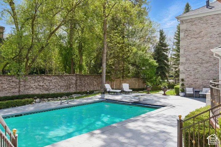 View of pool with a patio area and a fenced backyard