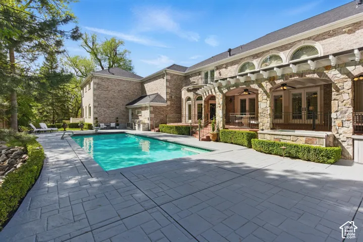 Swimming pool featuring a ceiling fan and a patio area