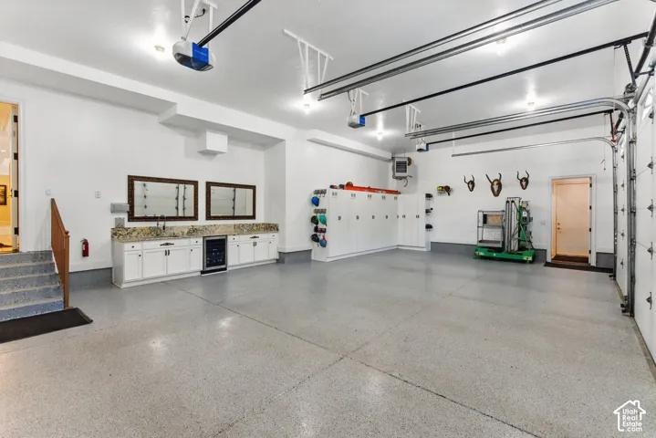 Garage featuring beverage cooler, a heating unit, and a garage door opener