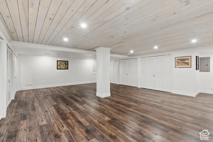 Below grade area with wooden ceiling, dark wood-style flooring, and recessed lighting