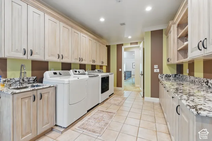 Washroom featuring cabinet space, recessed lighting, light tile patterned flooring, and separate washer and dryer