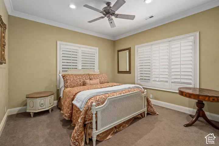 Carpeted bedroom with crown molding, ceiling fan, and recessed lighting
