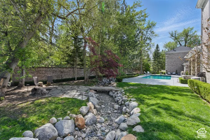 Fenced yard featuring a patio area and view of scattered trees