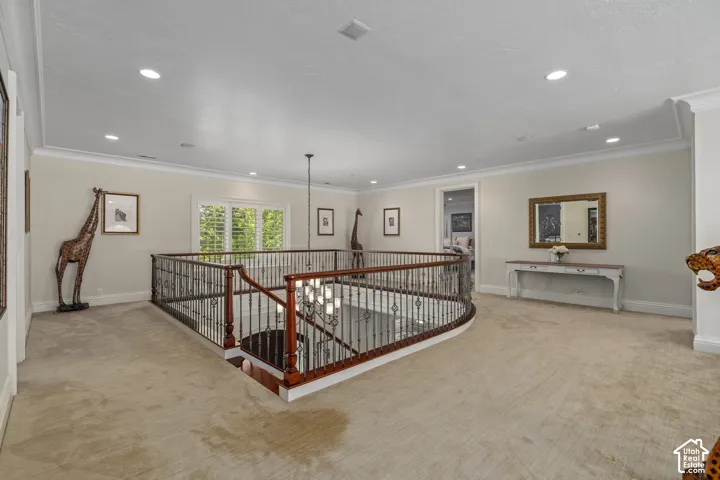 Hall with an upstairs landing, crown molding, light carpet, and recessed lighting