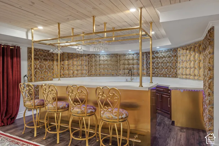 Indoor wet bar with wood ceiling, light countertops, dark wood finished floors, brown cabinets, and recessed lighting