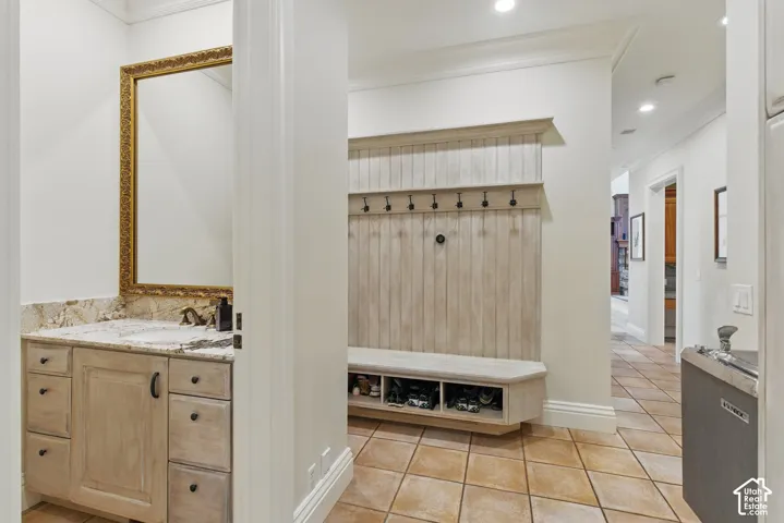Mudroom with light tile patterned floors, crown molding, and recessed lighting