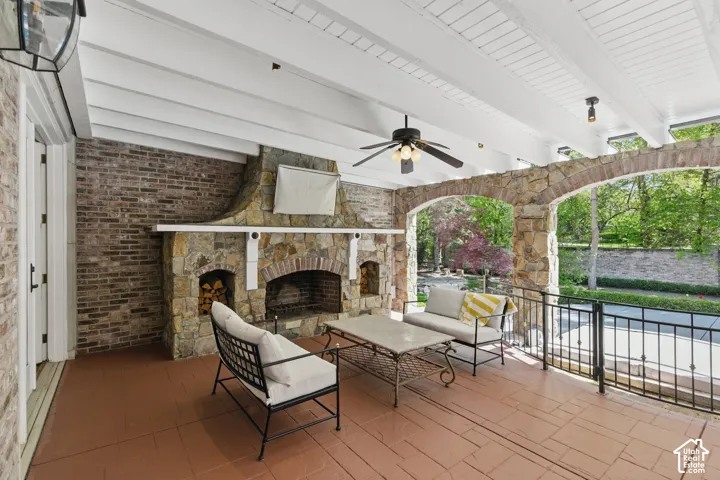 View of patio / terrace with an outdoor living space with a fireplace and ceiling fan
