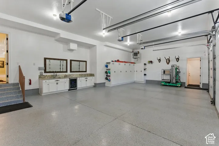 Garage featuring a heating unit, wine cooler, and a garage door opener