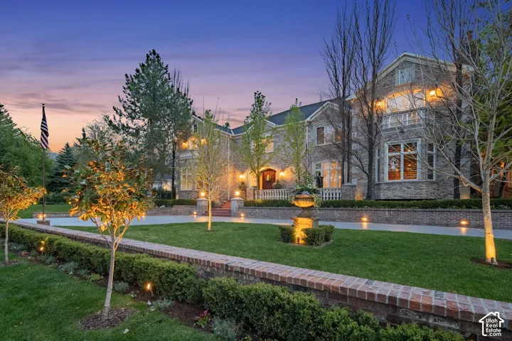 View of front of house with stone siding and a lawn